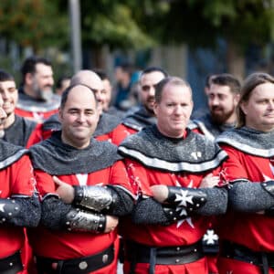 Hombres en trajes medievales rojos en fila