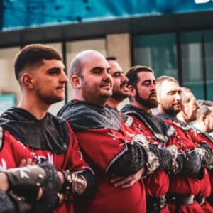 Hombres en trajes medievales rojos, desfile festivo