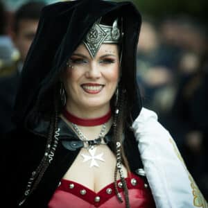 Persona con disfraz medieval en desfile festivo.