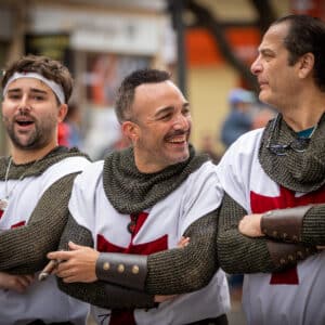 Hombres disfrazados de caballeros medievales en desfile.