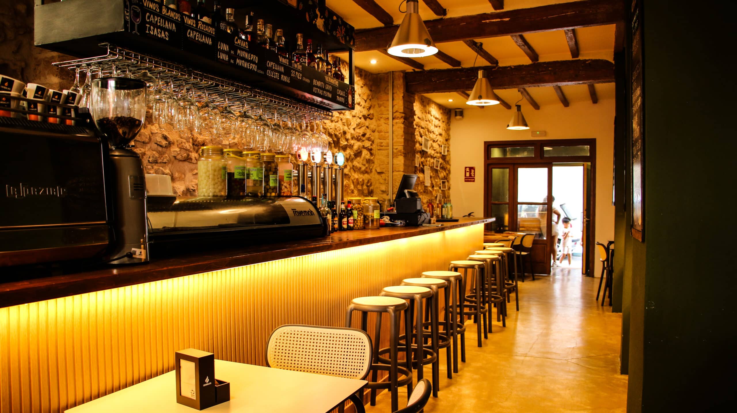 Interior de bar acogedor con barra y taburetes.