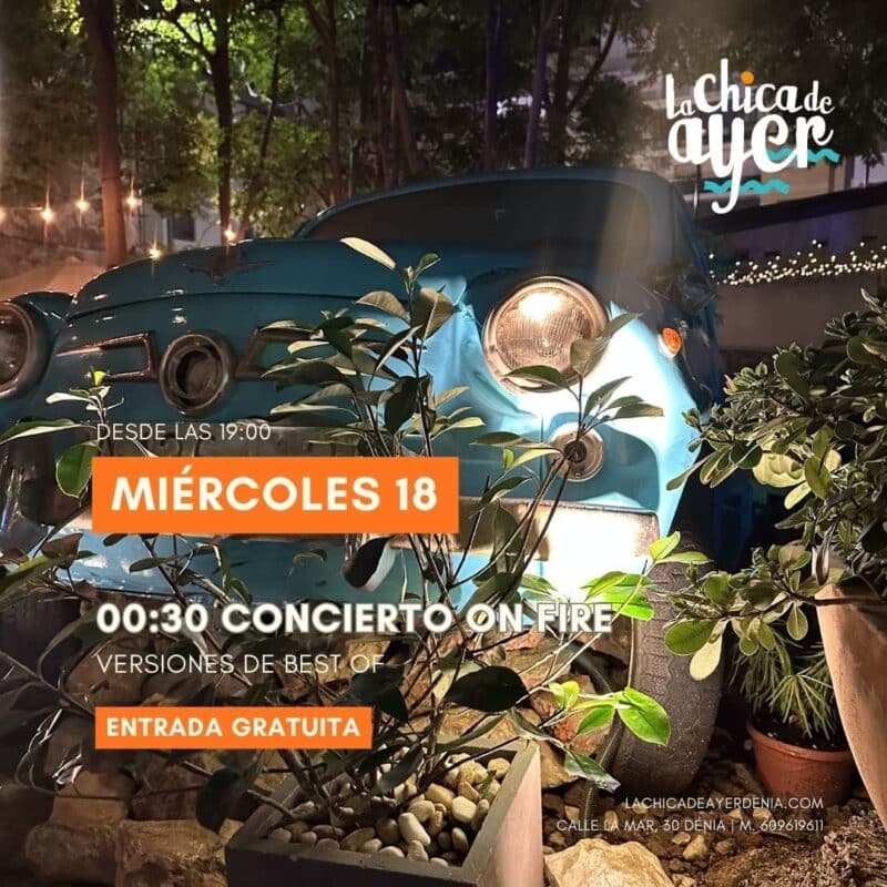 Coche clásico azul entre plantas y luces nocturnas