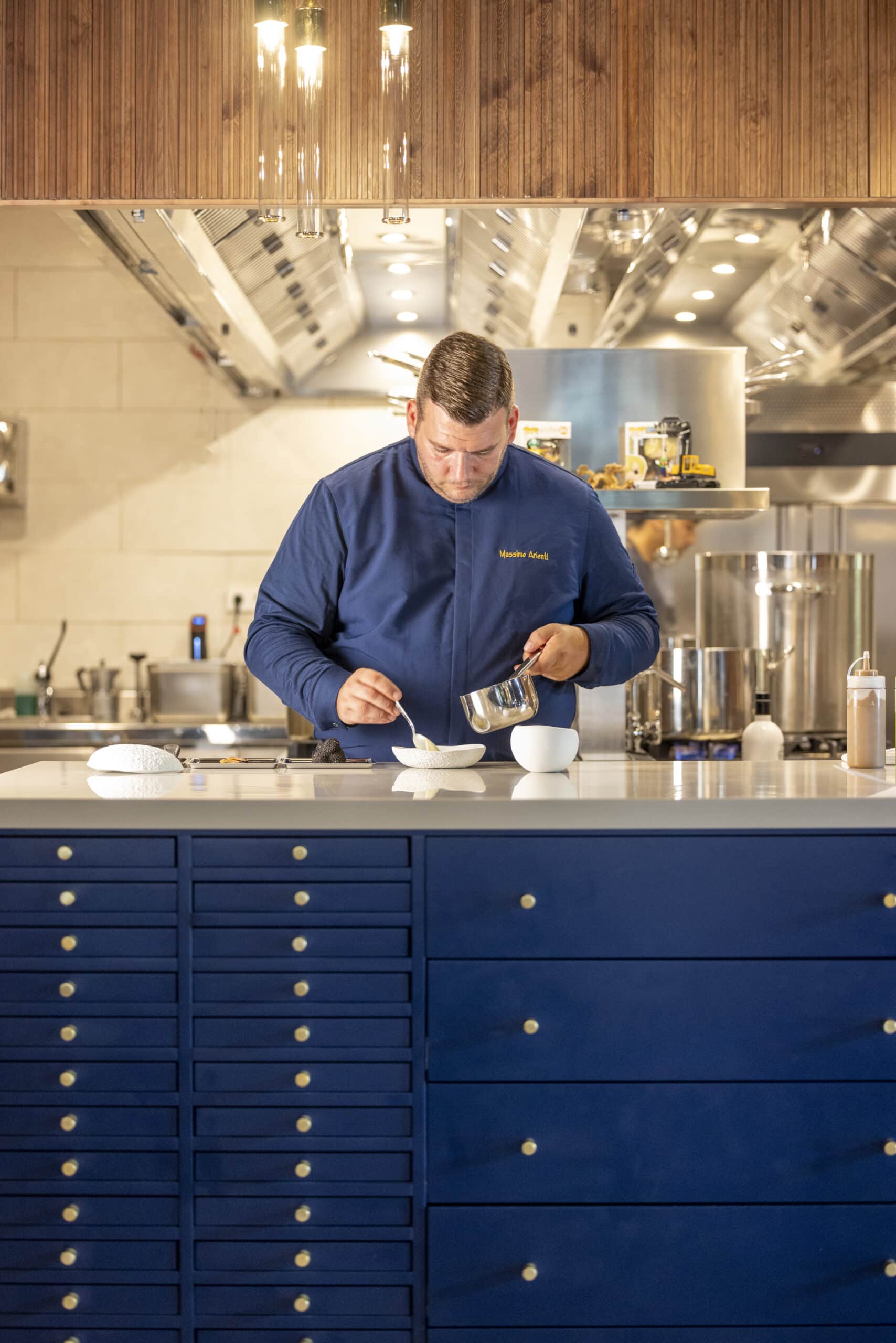 Chef emplatando plato en cocina profesional moderna