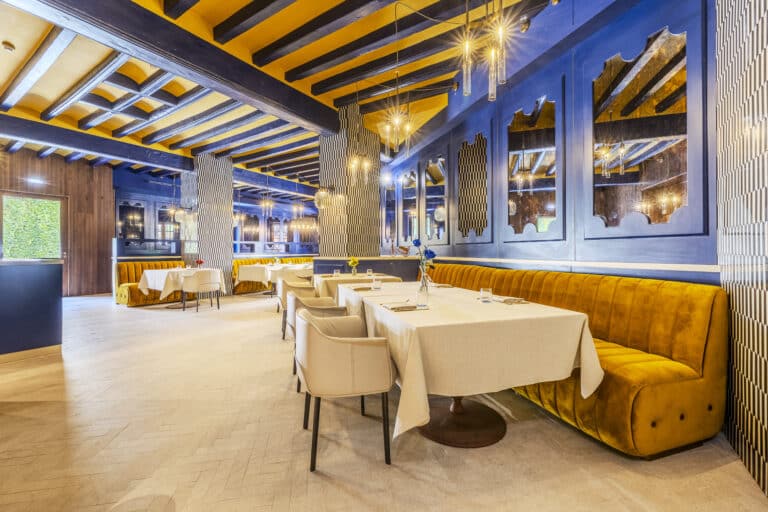 Restaurante elegante con bancos mostaza y paredes azules