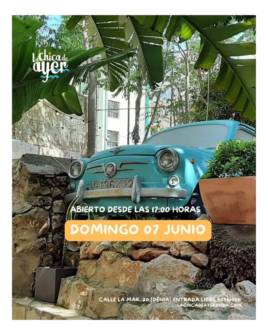 Coche clásico turquesa entre plantas tropicales
