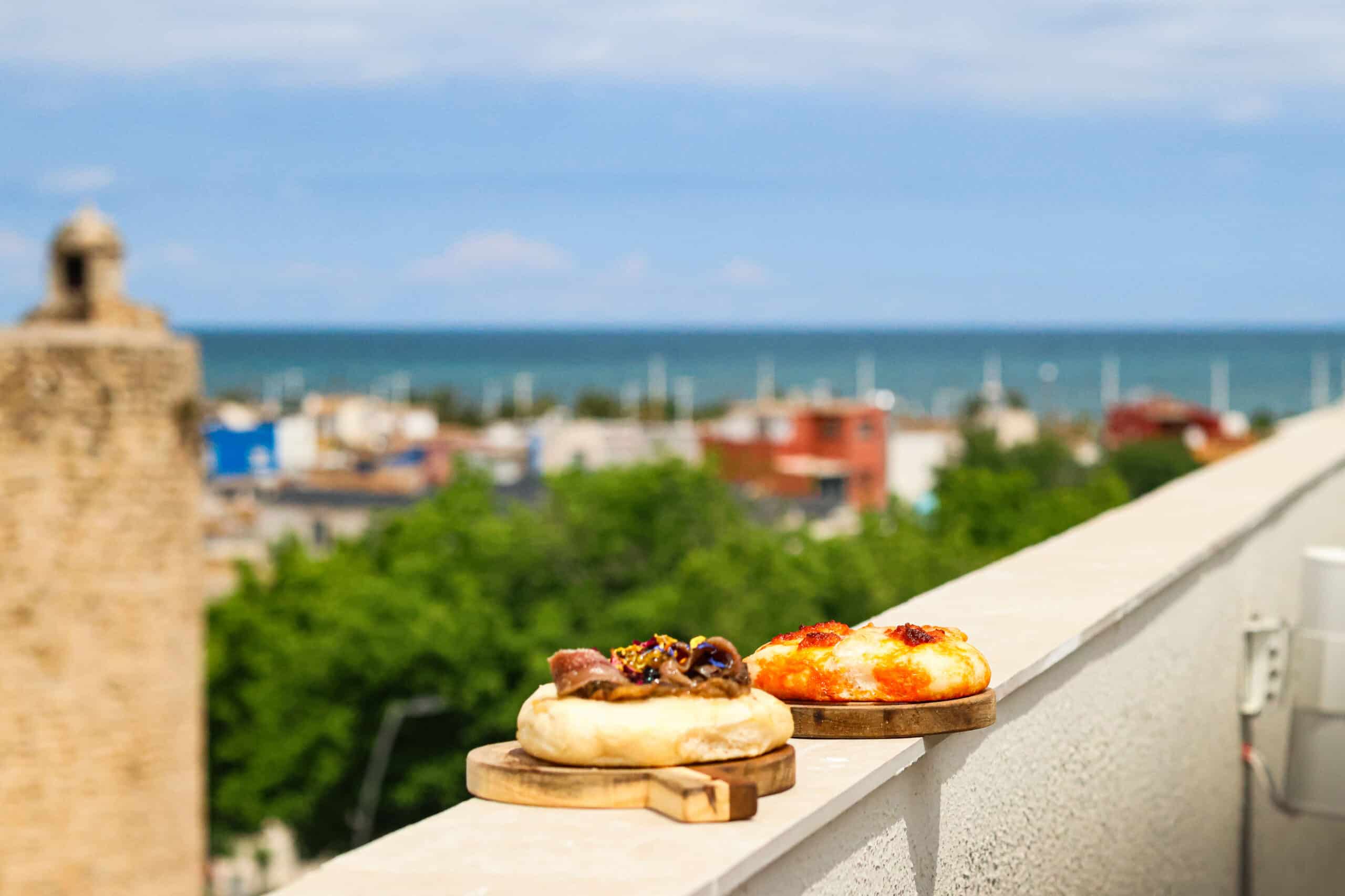 Dos mini pizzas artesanales en terraza con vistas al mar