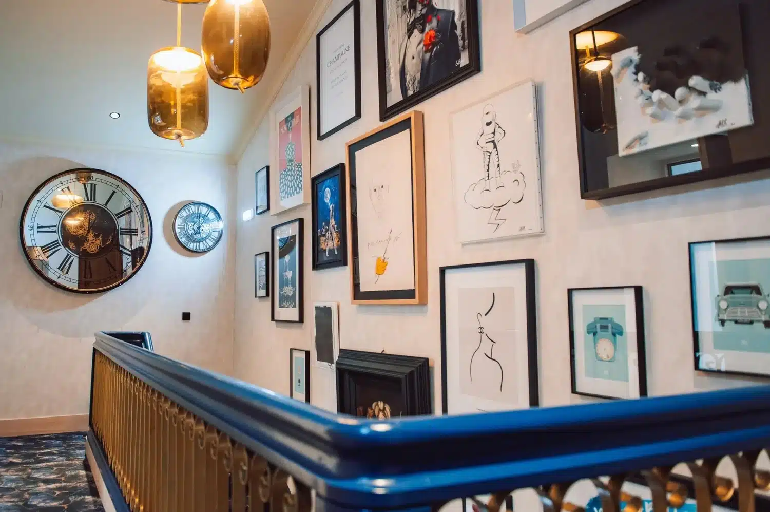Zona común de Nomada House con obras de arte y relojes de pared