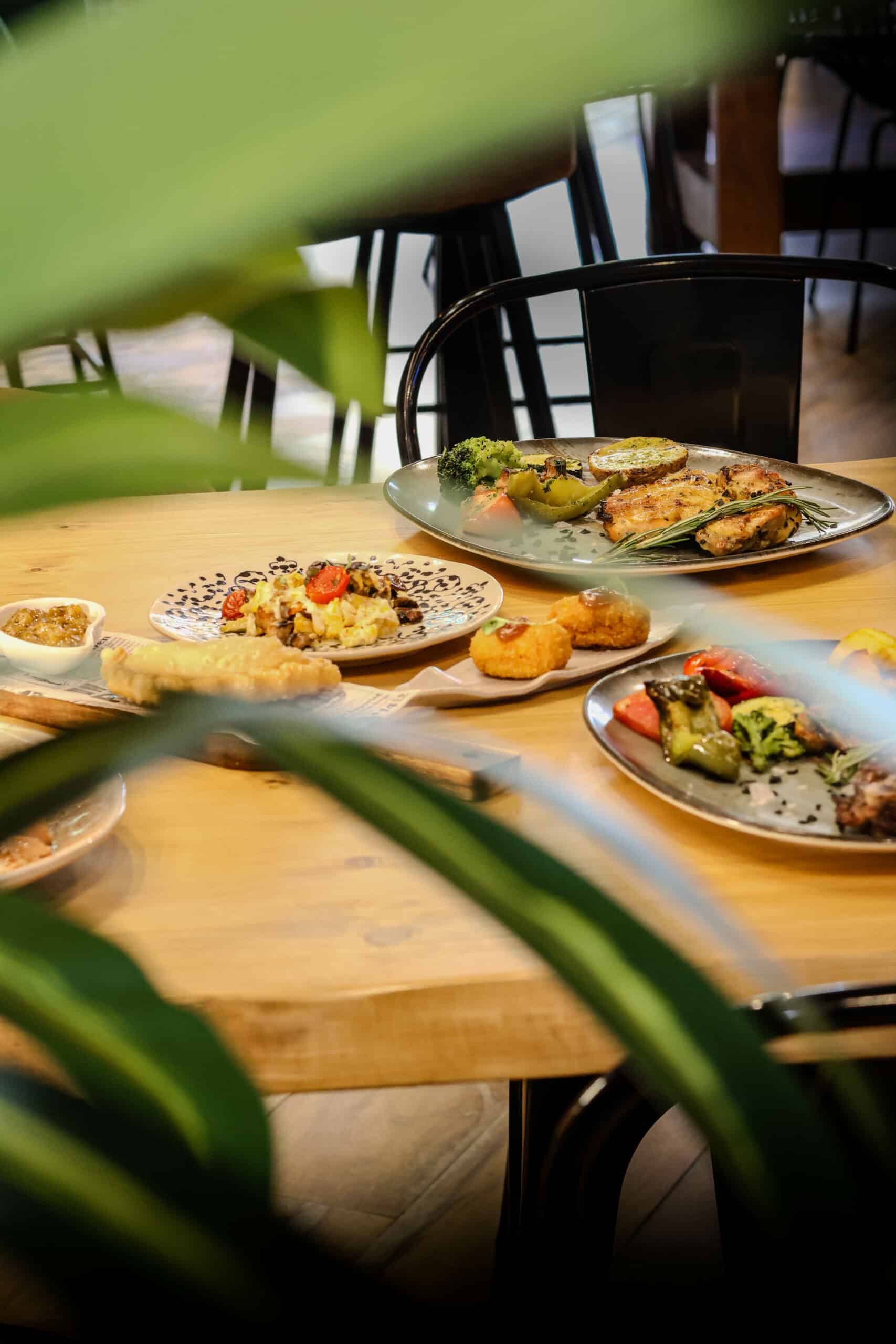 Varios platos de comida sobre mesa de madera en restaurante